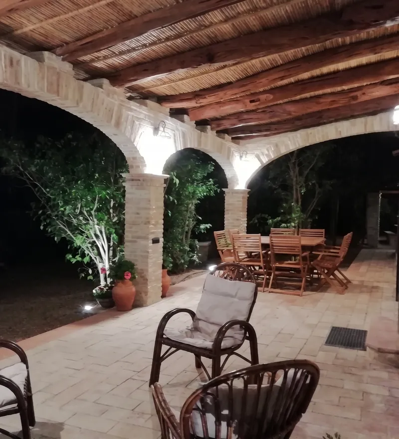 Veranda in stile campidanese con struttura in mattoni, pilastri e copertura in legno