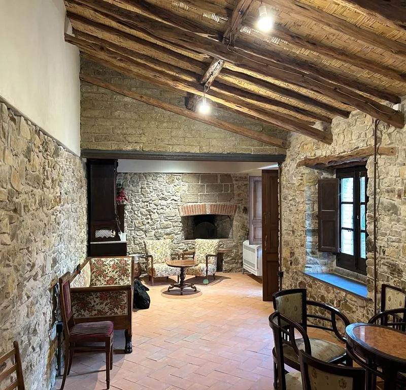 Interno della casa campidanese recuperata a Sanluri, con pietra a vista, travi in ginepro e cotto sardo